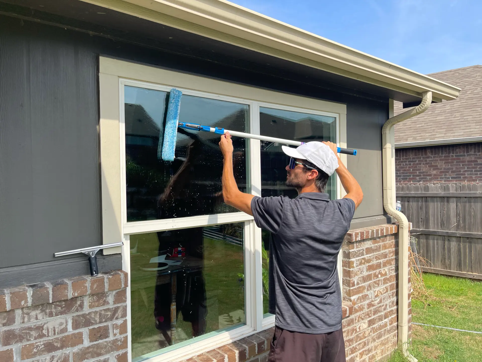 Austin carefully finishing a residential window by hand